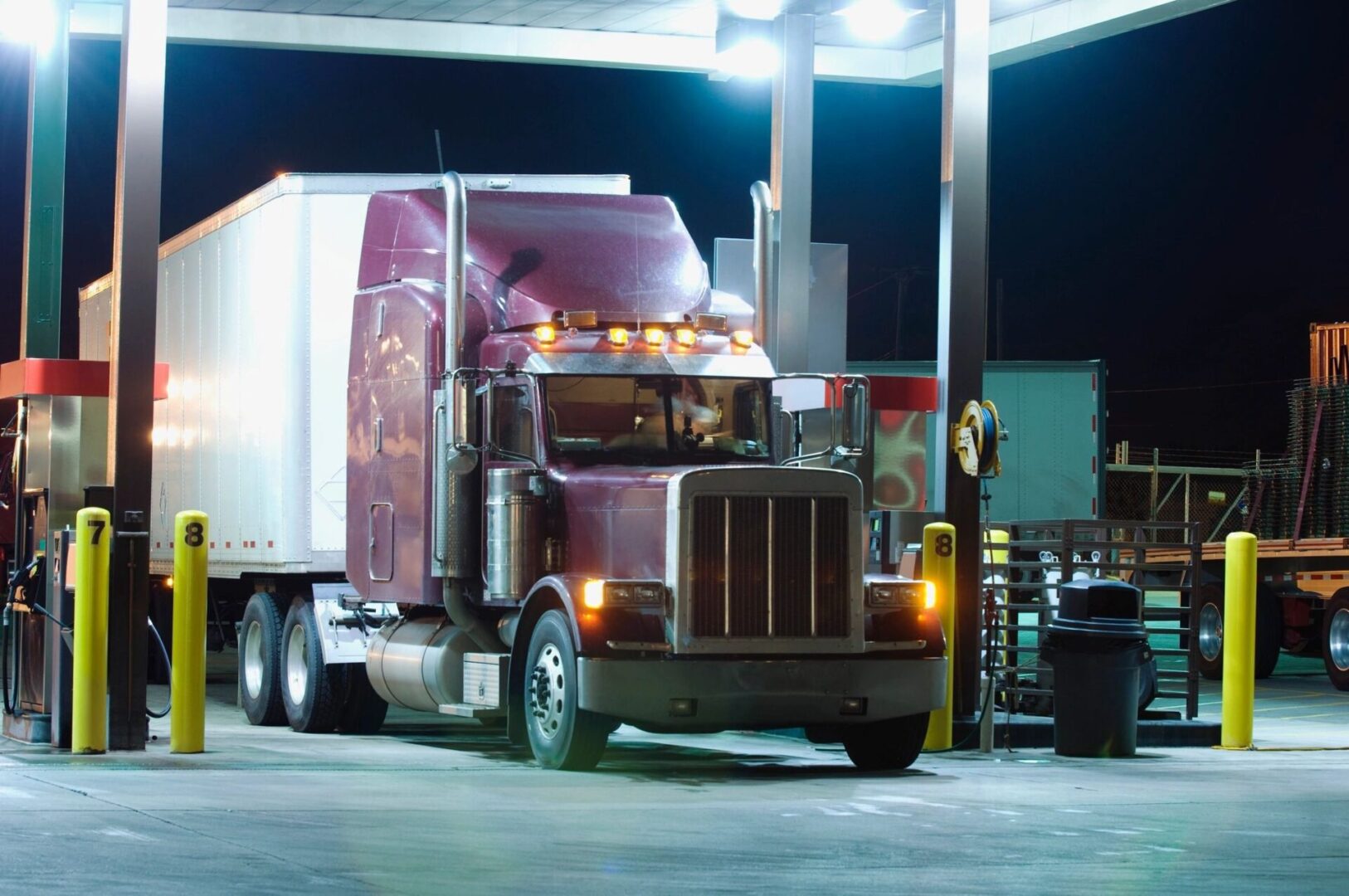 A semi truck is parked at the gas station.